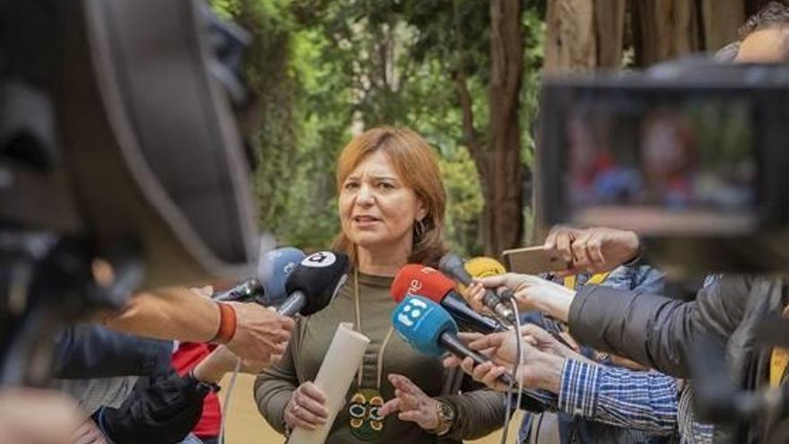 La presidenta del PP, Isabel Bonig, atendiendo a los periodistas en el jardín de las Cortes.
