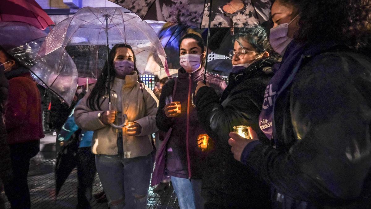 Un grupo de chicas portan vela en memoria de las mujeres asesinadas por violencia de género, en Badajoz, durante la marcha del 25 de noviembre