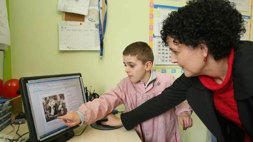 Iago Lorenzo Casal con su madre Inés señala un momento de su corto en el ordenador, en su colegio Aceesca, Porriño. // Jesús de Arcos