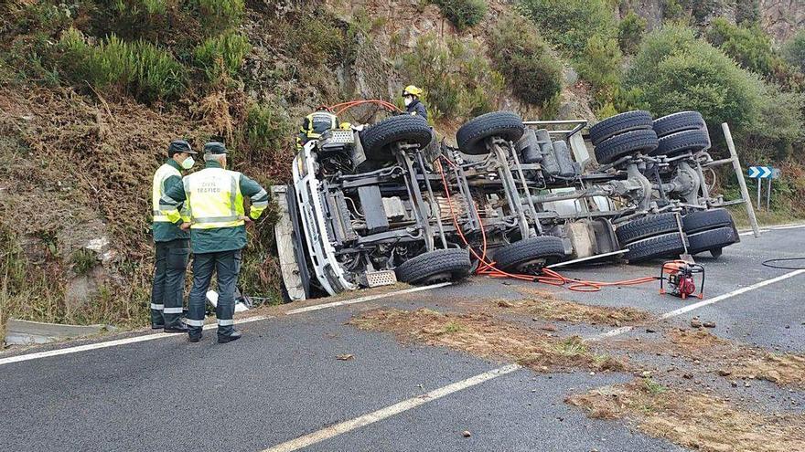 El camión hormigonera en el arcén de la vía volcado con el conductor todavía dentro de la cabina.