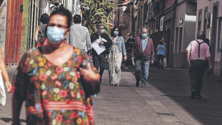 Viandantes con mascarillas por la céntrica calle Herradores.