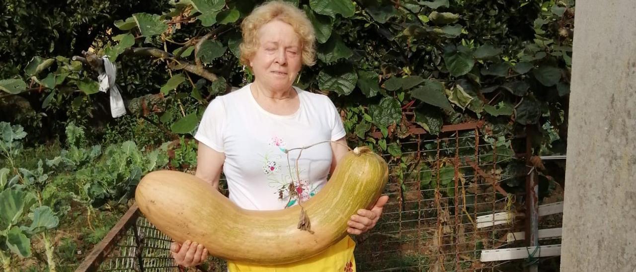 Carmiña Rodríguez con el calabacín gigante en su huerta.