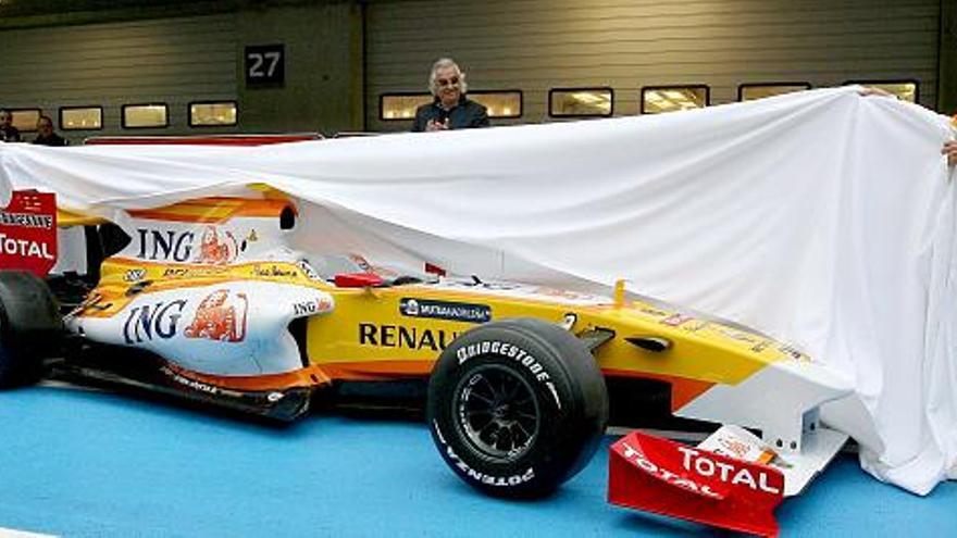Los pilotos de la escudería Renault, el brasileño Nelson Piquet Jr. (dcha) y el español Fernando Alonso (izq), desvelan el Renault R29 en presencia del jefe de la escudería, el italiano Flavio Briatore (c), durante la presentación del nuevo monoplaza de la escudería en el circuito portugués del Algarve hoy lunes 19 de enero.