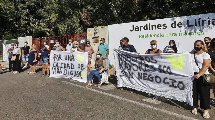 Familiares de los residentes del geriátrico DomusVi de Llíria sostienen pancartas durante la protesta de ayer en el centro.