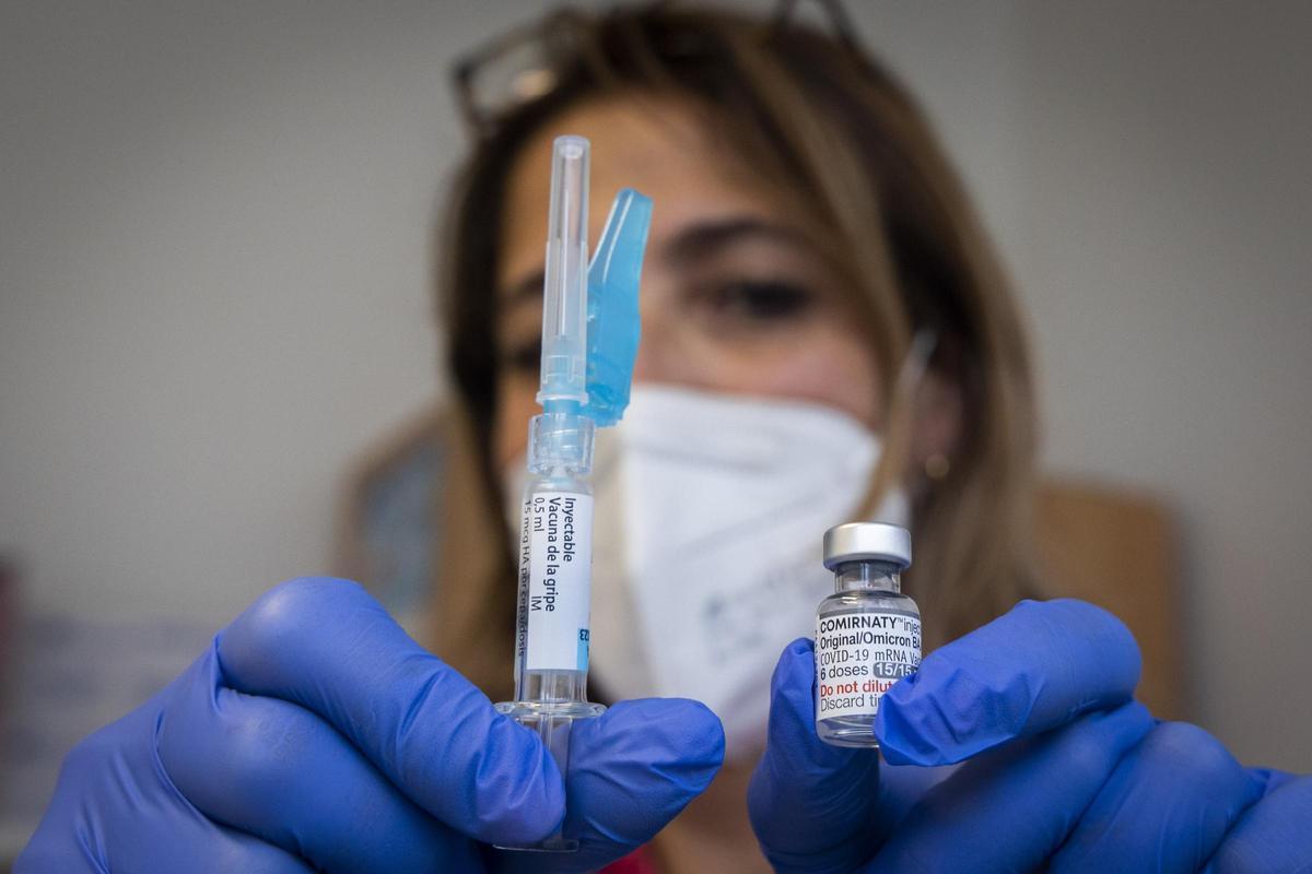 Una enfermera sostiene las dos dosis de vacuna, de gripe y covid, en el inicio de la campaña el año pasado.