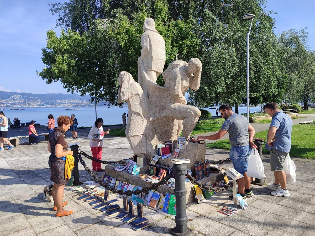 LIbros para repartir también colocados en la escultura al emigrante en el paseo de Moaña.