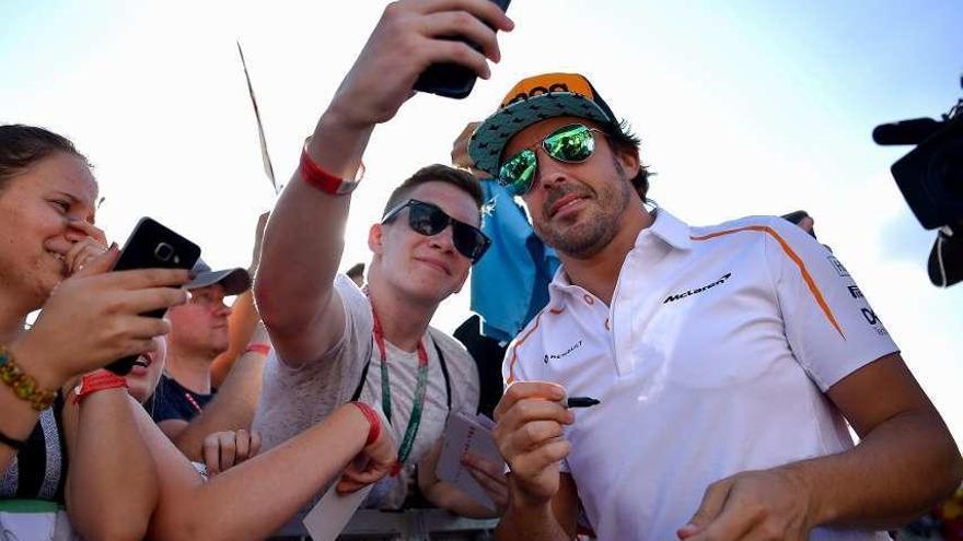 Alonso se hace una foto con un aficionado. // Efe