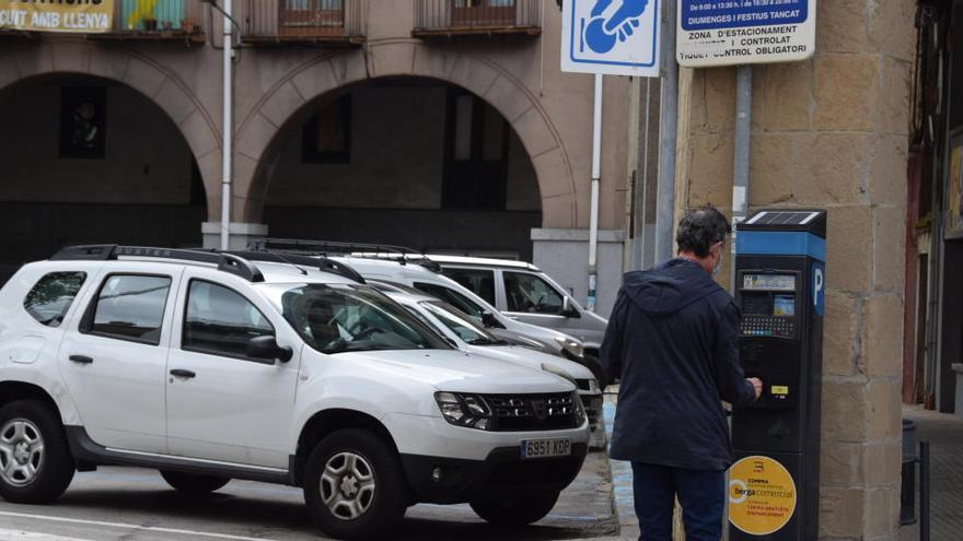 Un usuari paga la zona blava al parquímetre de la plaça Viladomat, aquest dilluns