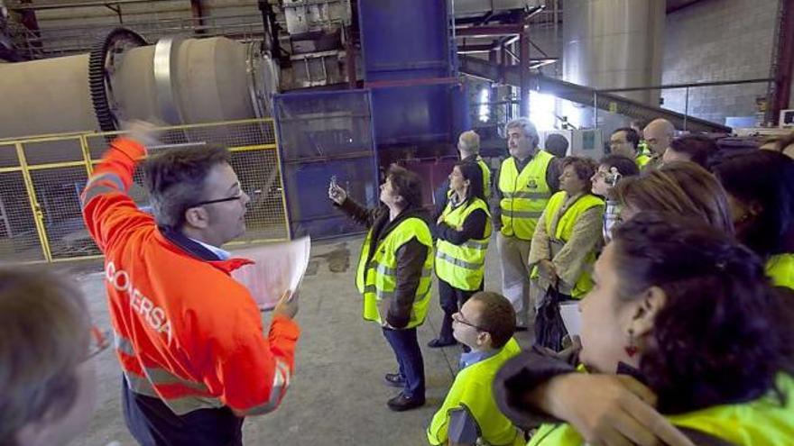 Arriba, personal sanitario y de Cogersa, durante la visita al horno rotativo. A la izquierda, material hospitalario dispuesto para procesarse en la planta de Serín. | miki lópez