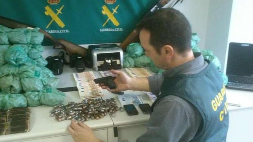 Un agente de la Guardia Civil muestra todo el material incautado a la red de Luciano Núñez.