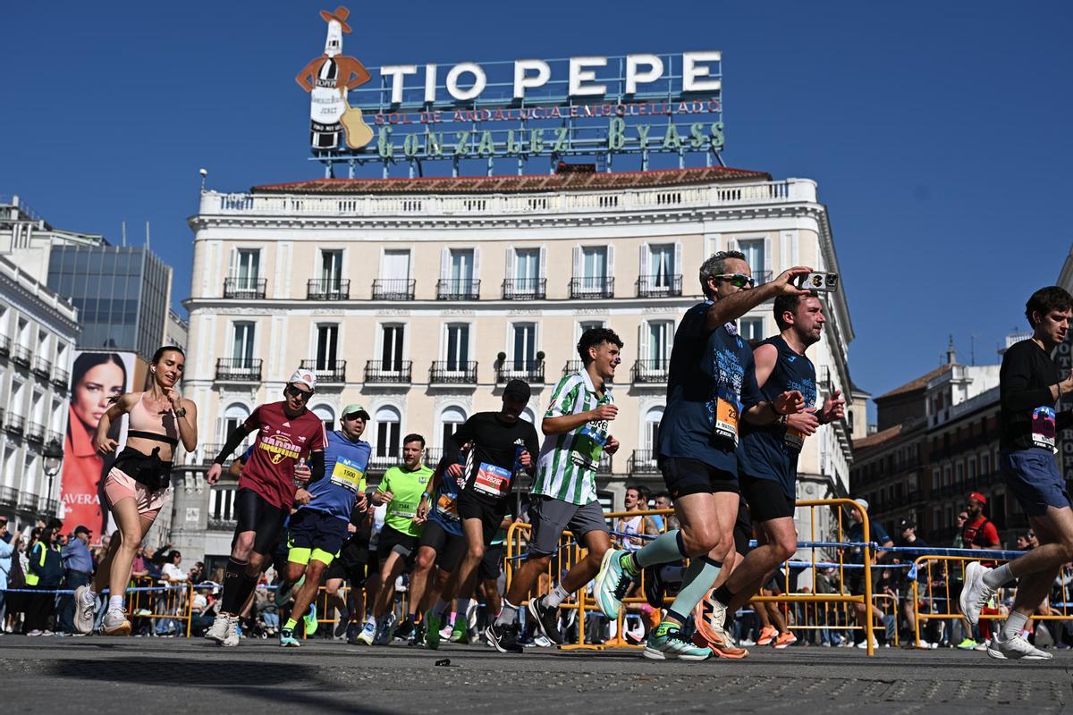 Varios atletas a su paso por la Puerta del Sol durante el Medio Maratón de Madrid este domingo.