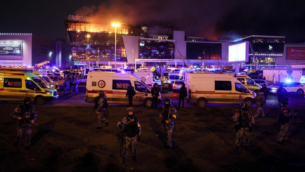 Policías asegurando el perímetro tras el incendio provocado por el tiroteo en una sala de conciertos en Moscú