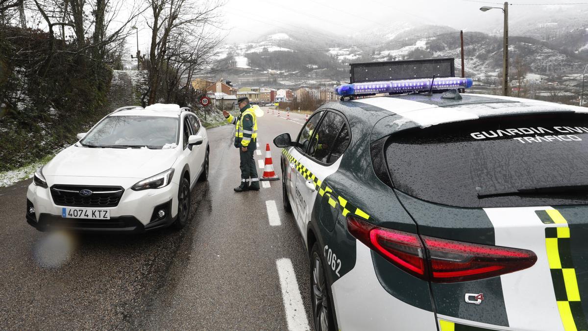 Un agente de la Guardia Civil de Tráfico informa en Campomanes a un conductor que se dirige hacia Pajares. TEMPORAL. NIEVE. BORRASCA "FIEN". CAMIONES. CAMIONEROS ESPERANDO APERTURA DEL HUERNA EN POLA DE LENA