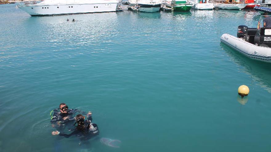 Dos buzos durante las labores de limpieza del muelle de Caleta de Fuste..