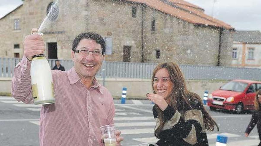 El propietario de la administración de O Burgo que repartió el quinto premio, Francisco Javier Díaz, ayer junto a una de sus empleadas, Aida Díaz, ante la iglesia de Santiago