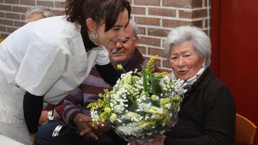 Carolina Rodríguez entrega un ramo de flores a la homenajeada. // I. O.