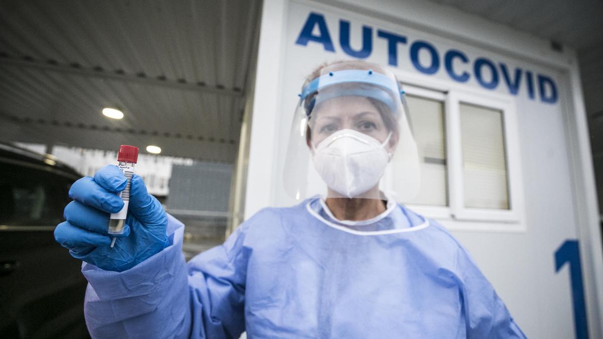 Una trabajadora sanitaria con la muestra para una prueba PCR.