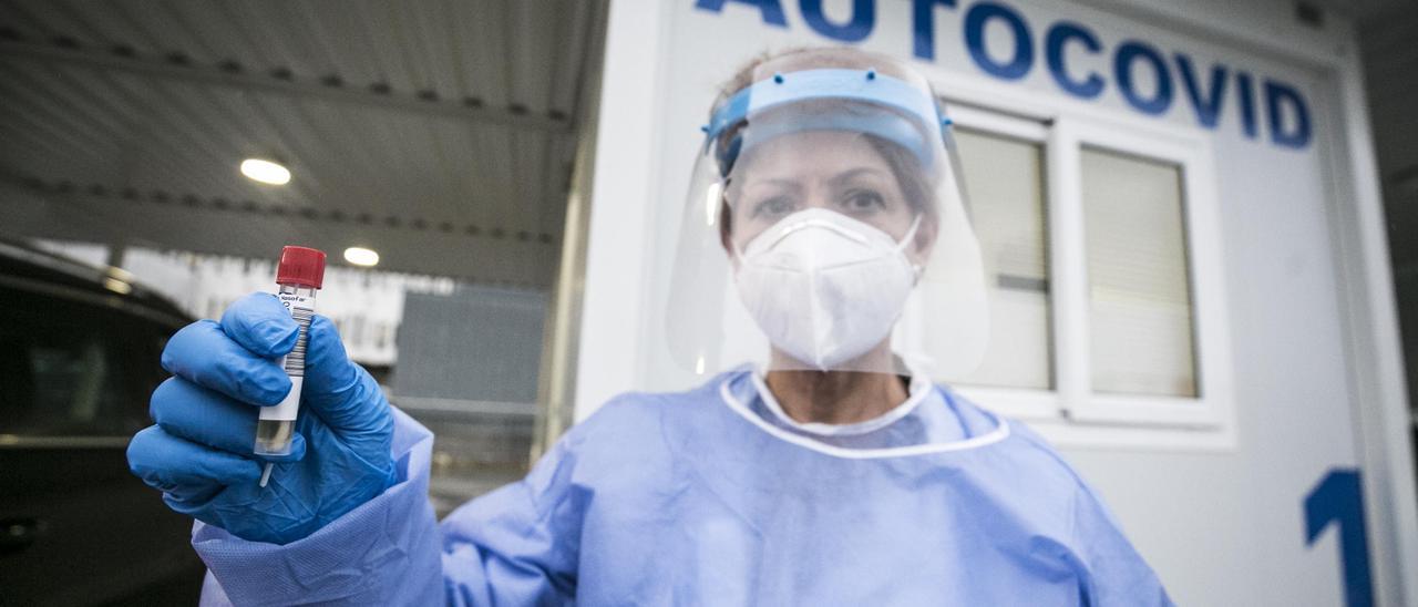 Una trabajadora sanitaria con la muestra para una prueba PCR.