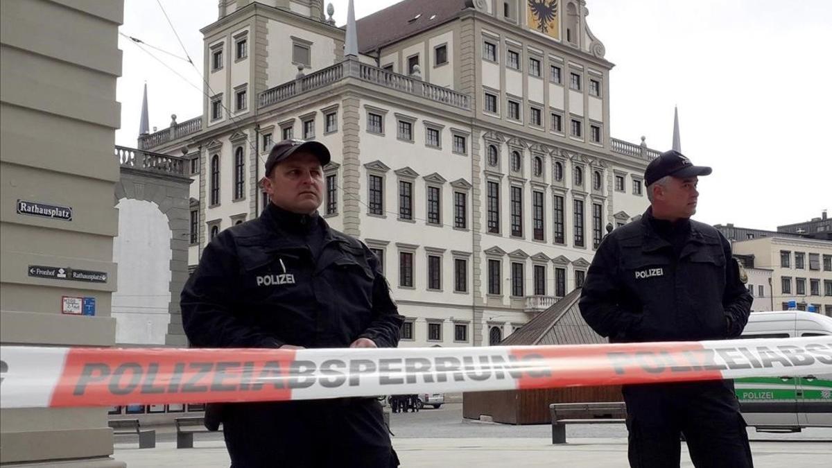 Dos policias vigilan junto al cordón de seguridad colocado en las proximidades del Ayuntamiento de Augsburgo, en Alemania.