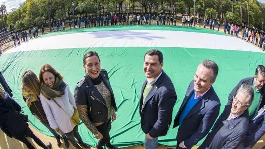 Juanma Moreno y otros dirigentes del PP-A desplegaron en Sevilla la bandera andaluza más grande de España.