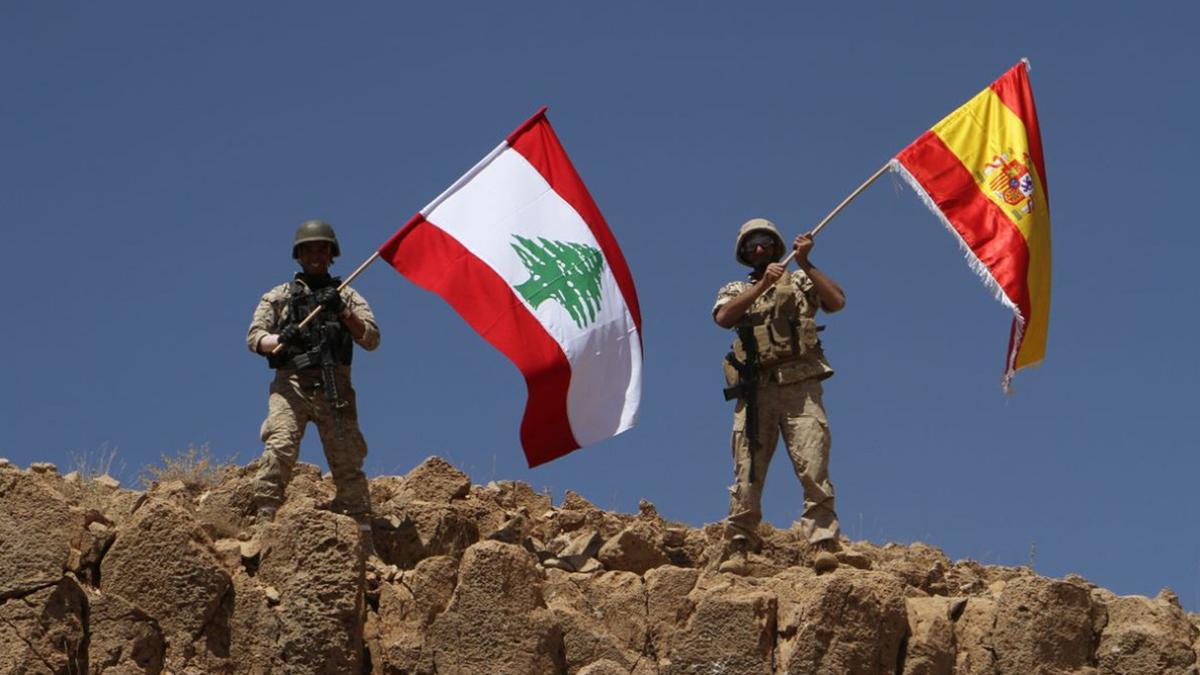 Dos soldados ondean las banderas libanesa y española tras recuperar parte de la región de Ras Baalbek.