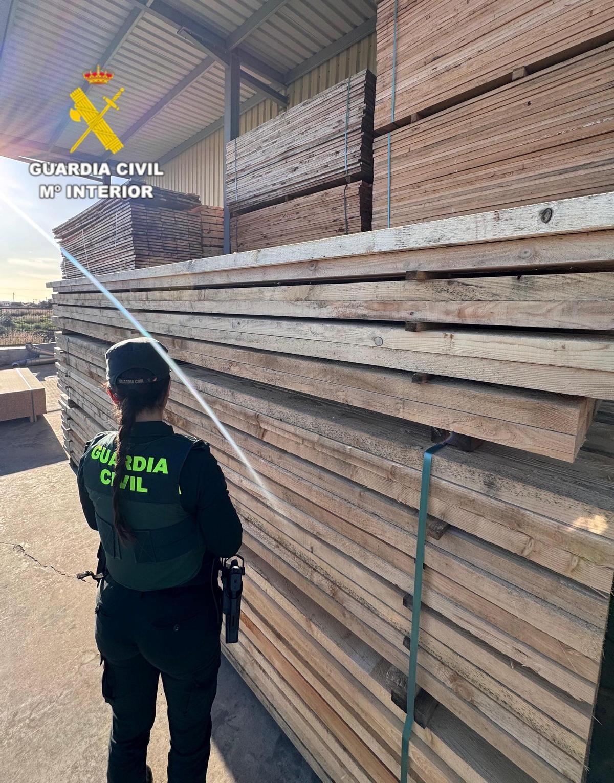 Una agente de la Guardia Civil, junto a parte de la mercancia incautada.