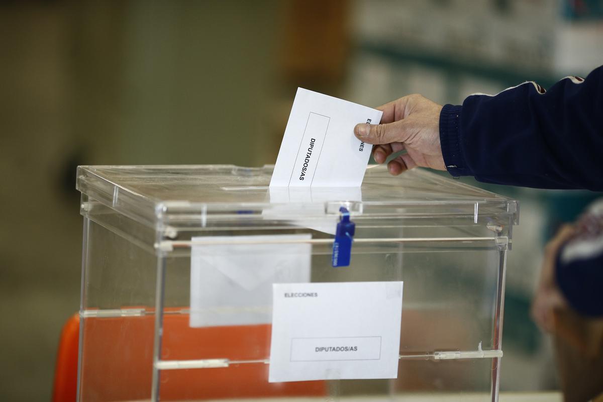 Una persona deposita una papeleta en una urna de unas elecciones en España.