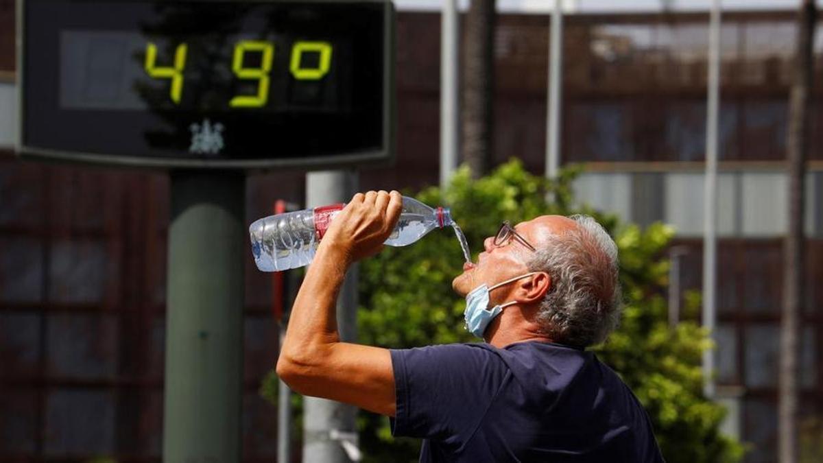Un home beu aigua a Còrdova durant una onada de calor.