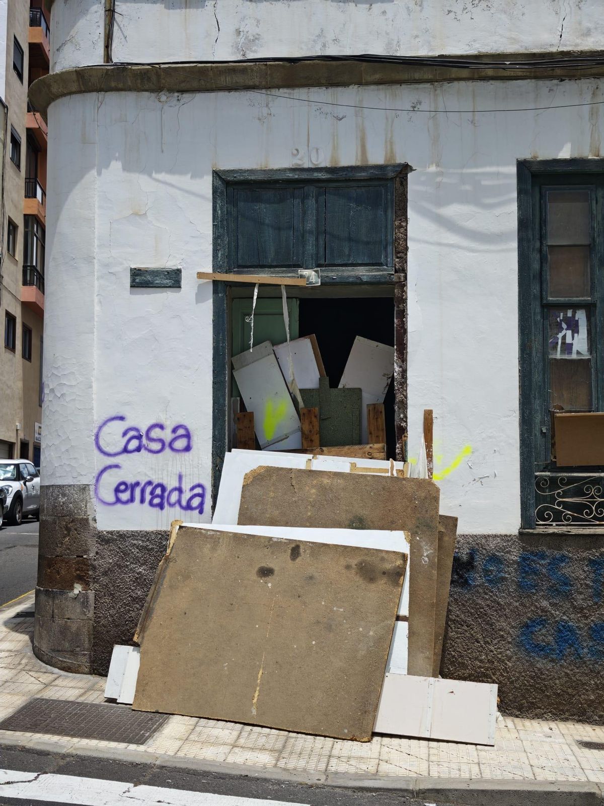 Tablones que bloquean la entrada de la casa después de que los okupas la abandonaran este sábado en El Toscal.