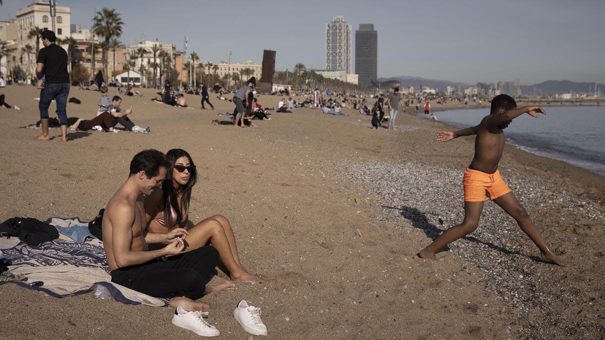 Bañistas y gente aprovechan este día de calor en invierno en la playa de la Barceloneta