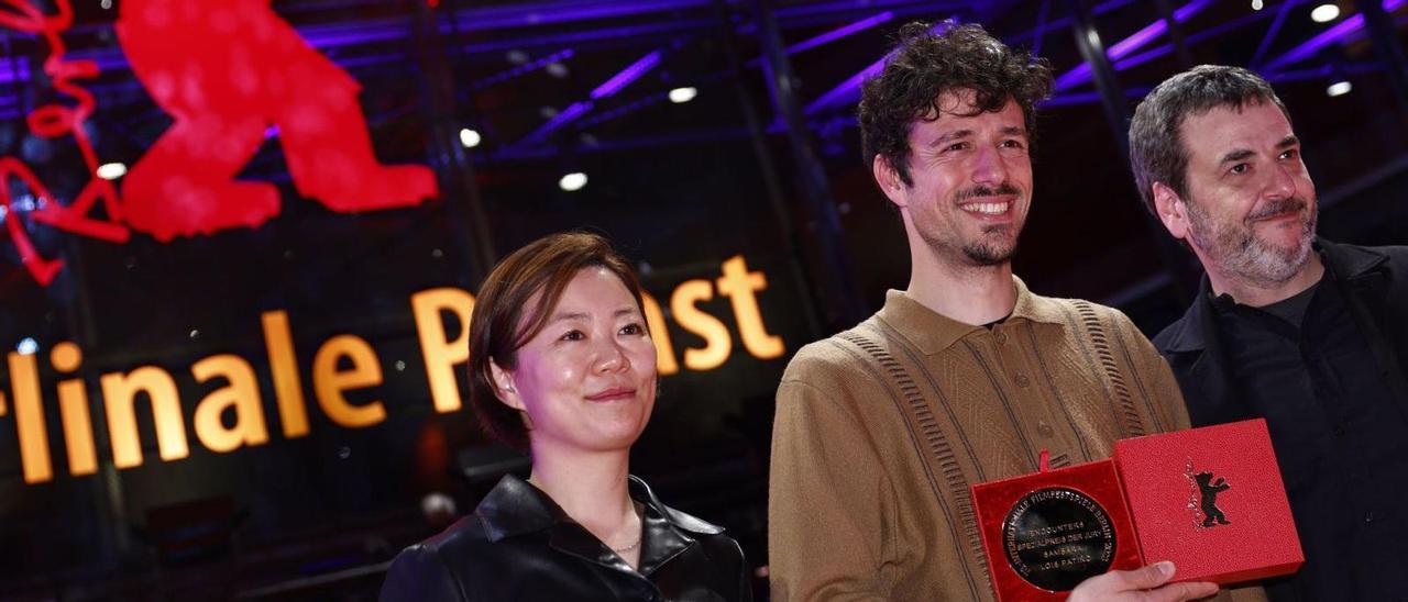 Lois Patiño, en el centro, con su premio de la Berlinale en la noche  del sábado.  / EFE