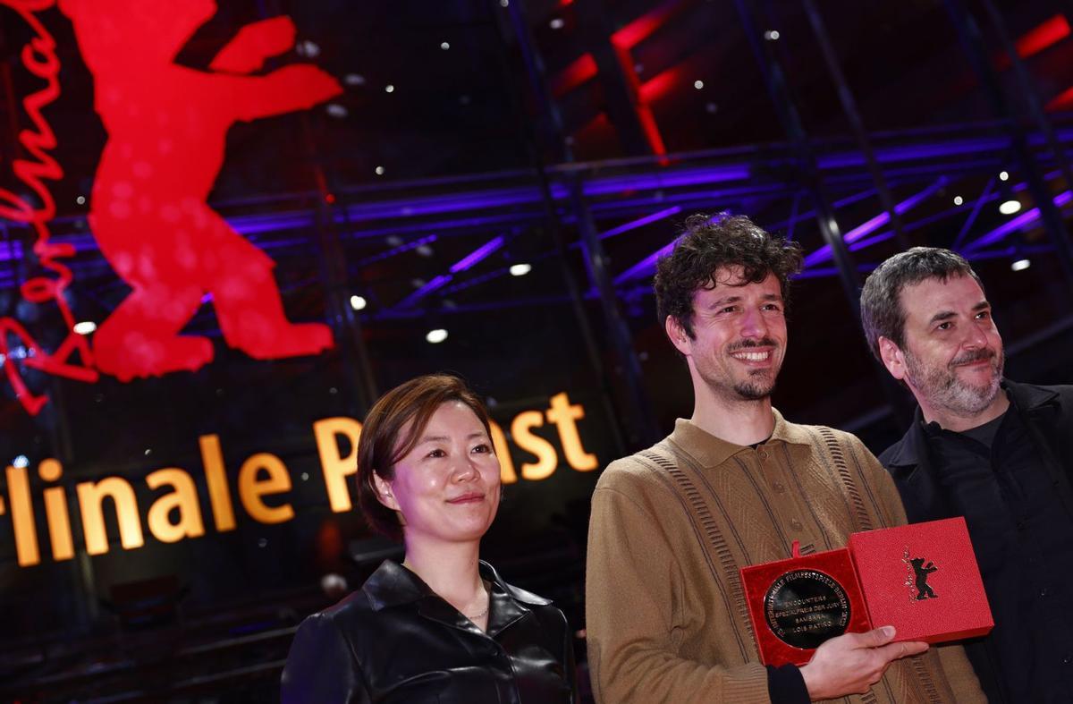 Lois Patiño, en el centro, con su premio de la Berlinale en la noche  del sábado.  / EFE