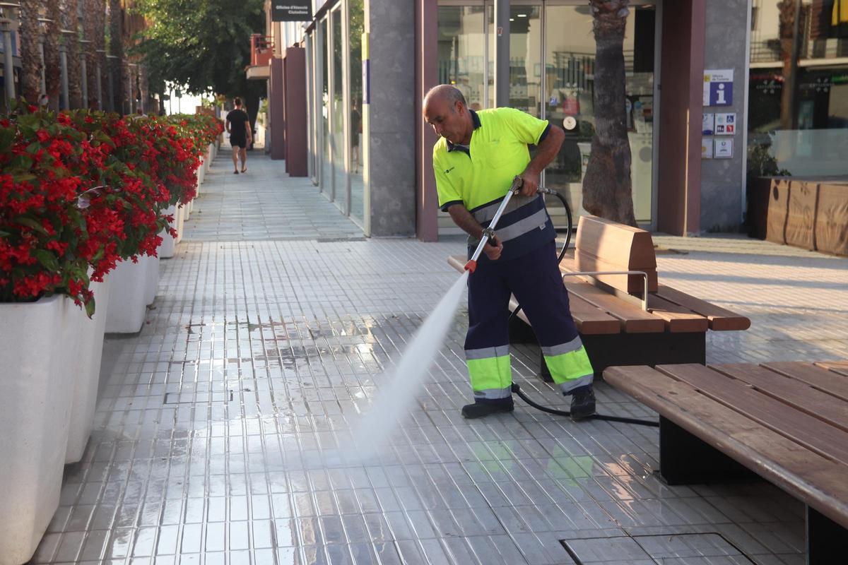 Un tècnic neteja el terra de Platja d'Aro amb una pistola d'aigua a pressió.