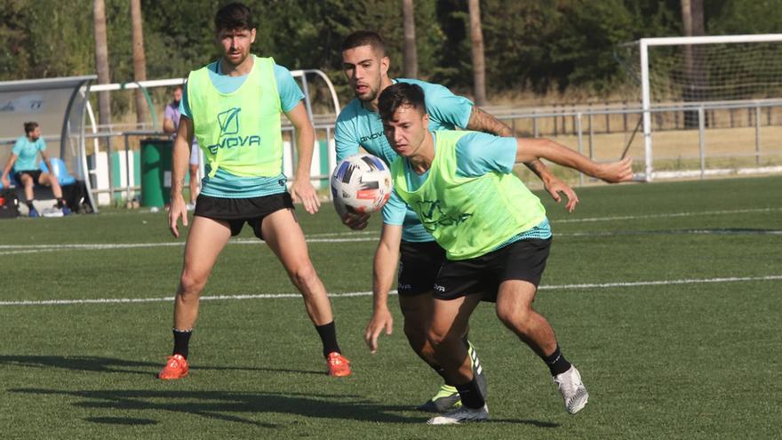 Ale Marín y Julio Iglesias pugnan por el balón ante la mirada de Javi Flores.