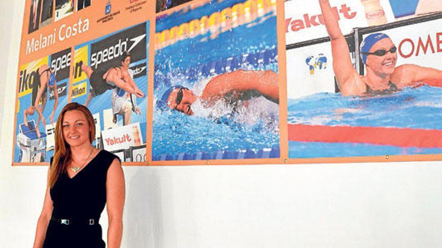 La nadadora mallorquina junto a uno de sus posters.