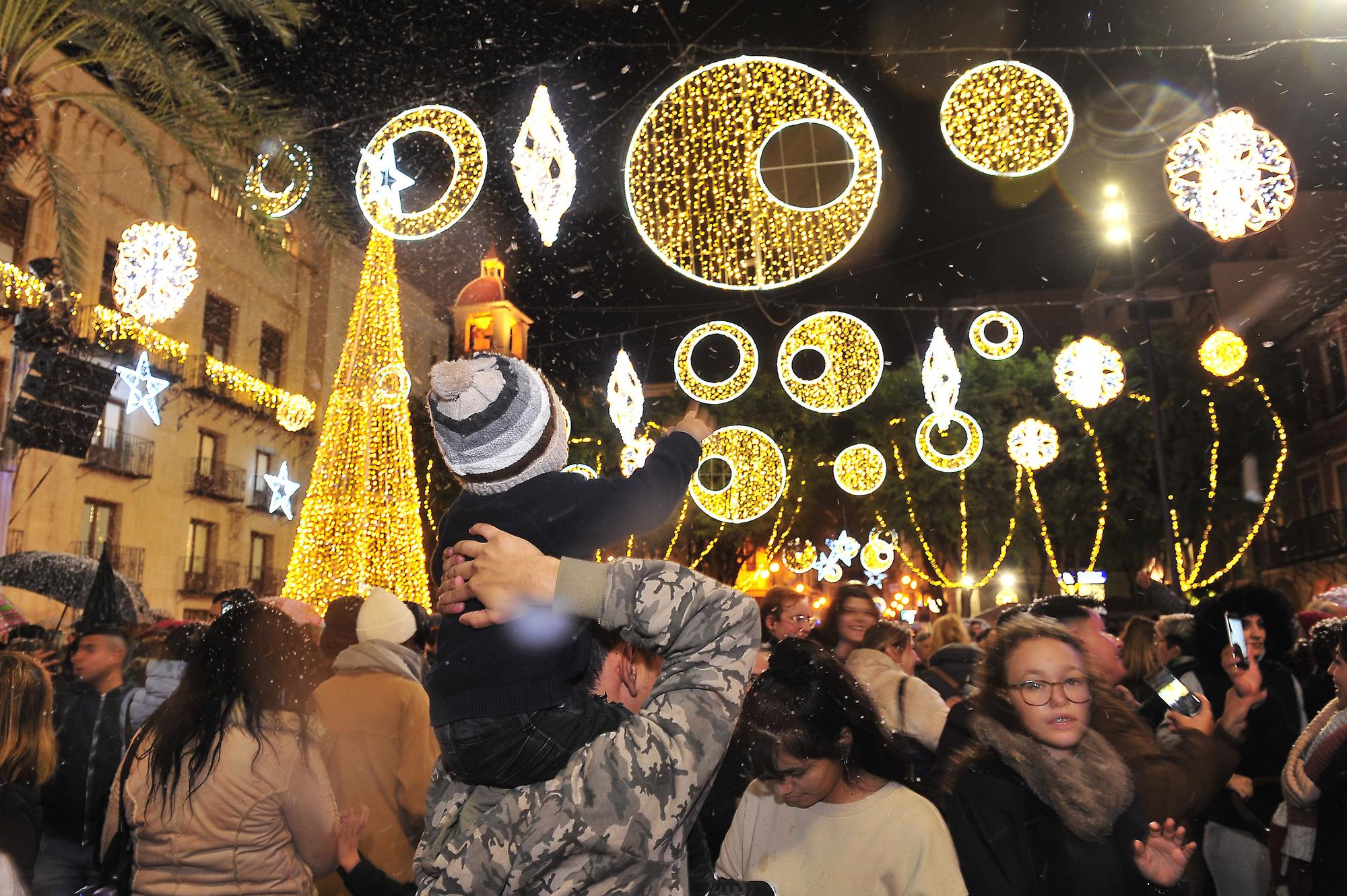 Elche enciende la Navidad con una gran "nevada" y... lluvia intermitente