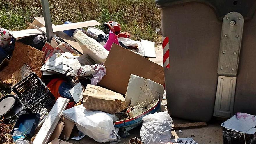 Un contenidor i deixalles a terra, en un carrer de Cassà de la Selva.