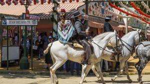 Un caballista bebiendo en el recinto ferial de la Feria de Abril de Sevilla en el día más caluroso del año a 26 de abril del 2023