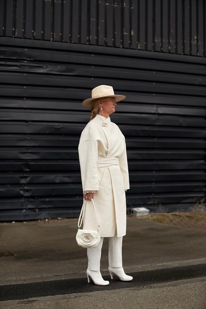 Look 'total white' con botas blancas visto en el 'street style' de invierno de Copenhague