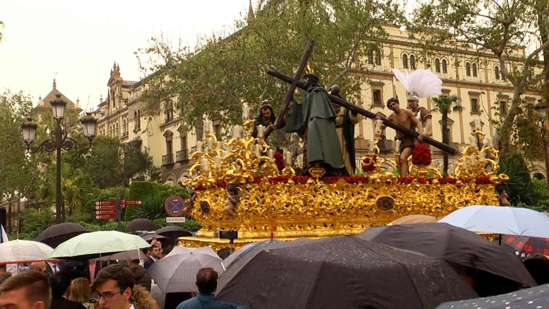 Nuestro Padre Jesús de la Victoria con capote verde desfila rodeado de paraguas