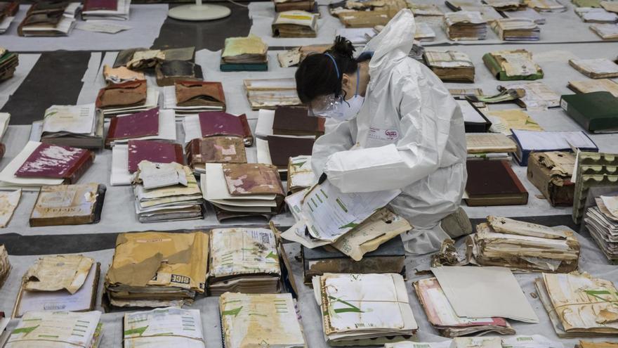 Una técnico del IVCR+i trabaja en Feria Valencia para la recuperación de los archivos históricos afectados por las inundaciones de la dana. | GERMÁN CABALLERO