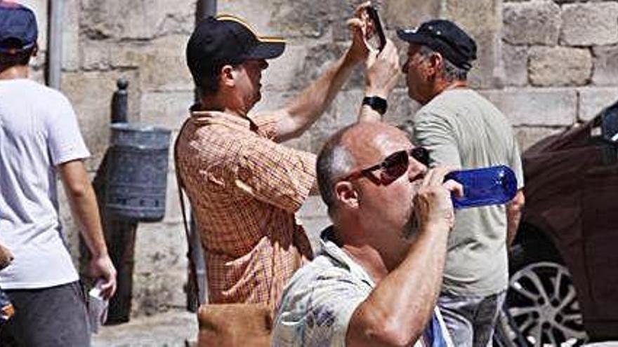 Turistes suportant la intensa calor durant la seva visita a la ciutat de Girona.