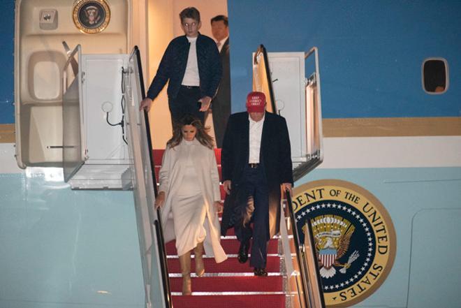 Melania Trump, con look blanco y botas altas camel