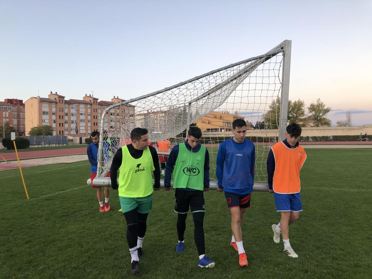 Los jugadores del Unami cargan con una portería en el entrenamiento.