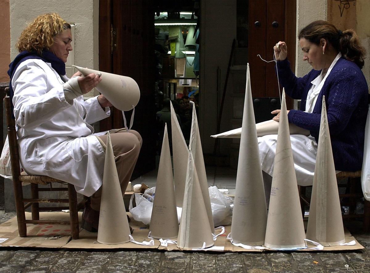 SEV.2. Sevilla, 11-04-04.- Carmen y Loli, empladas de una tienda especializada en la elaboraci?n de capirotes, que fabrican a medida para que encajen en la cabeza de los nazarenos, dan los ?ltimos retoques ante el inicio el domingo de la Semana Santa. Cada una de estas trabajadoras confeccionan unos 60 capirotes diarios, que son exportan a toda Espa?a. EFE/Emilio Morenatti??