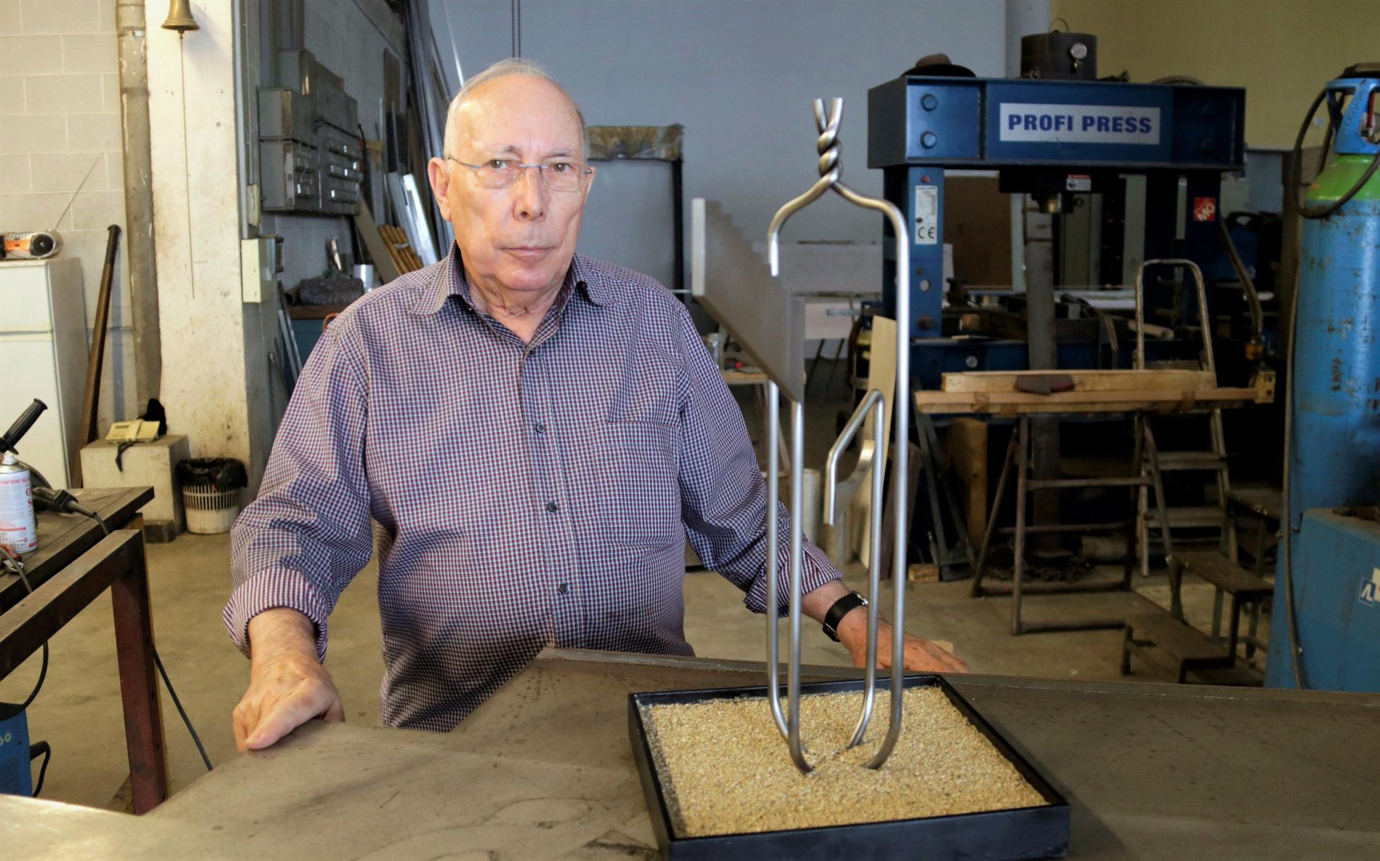 El escultor Pere Casanovas con una maqueta de la escultura sobre el covid-19, en su taller de Mataró.