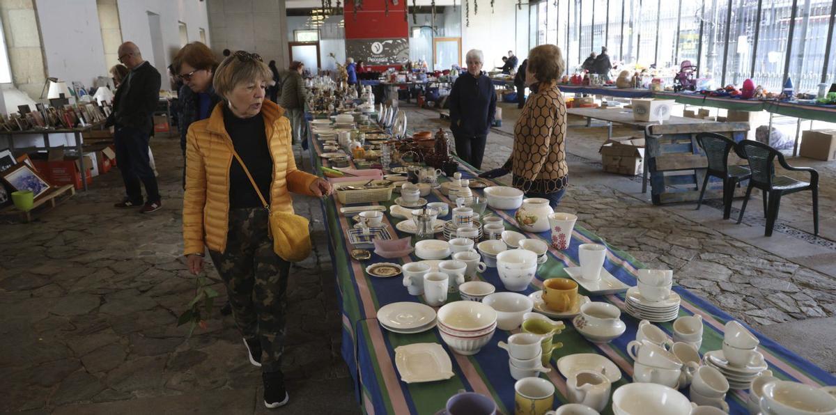Una mujer observa las piezas de loza puestas a la venta en el mercadillo de la Protectora. | NOÉ PARGA