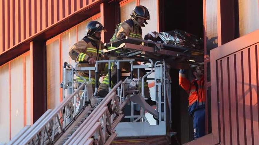 Bomberos trasladan al operario herido. // Nick