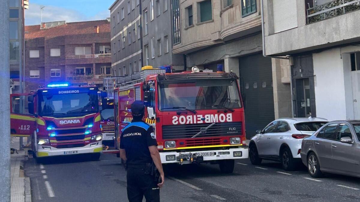 Los bomberos trabajando en las labores de extinción del incendio declarado en la calle Morón de Silleda.