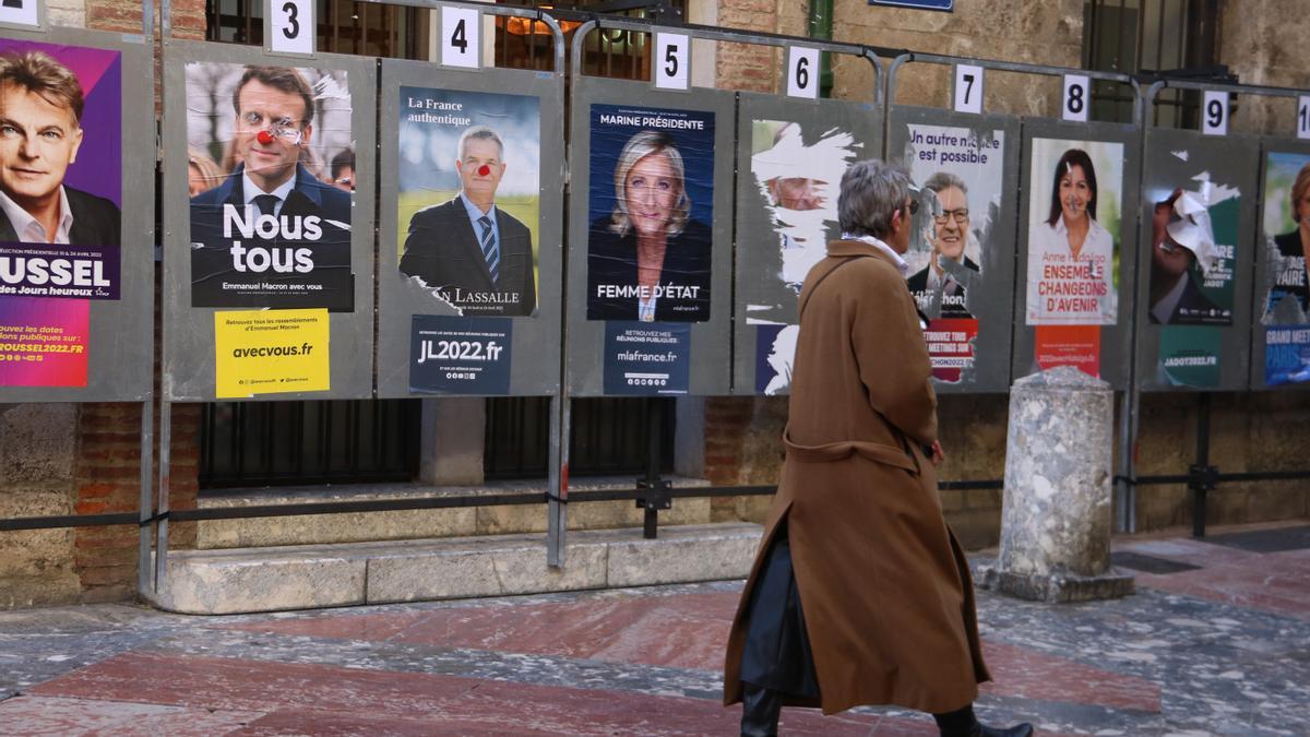 Una dona passa per davant de cartells electorals a Perpinyà
